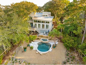 Stunning home with modern architectural details surrounded by lush landscaping and a beautiful pool and spa area at 608 W Beach Ct, Folly Beach, SC 29439