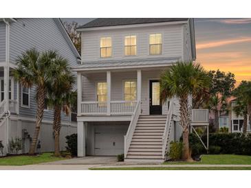 Charming two-story home with covered porch and well-manicured landscaping with palm trees at 775 Forrest Dr, Charleston, SC 29492