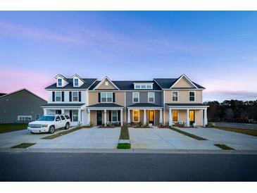 View of newly constructed townhomes boasting craftsman-style architecture and well-manicured lawns at 826 Alma Square Dr, Moncks Corner, SC 29461