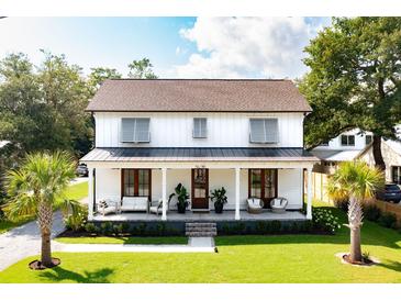 Charming two-story home boasting a welcoming front porch with comfortable seating and beautifully landscaped yard at 916 Kincade Dr, Mount Pleasant, SC 29464