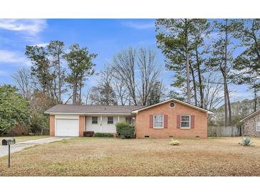 Charming single-story brick home with a well-maintained front yard, garage, and vibrant red shutters at 120 Carol Dr, Goose Creek, SC 29445