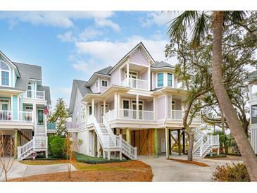 Three story elevated beach home with wrap-around porch and white railings at 1607 Folly Creek Way Way # C-5, Charleston, SC 29412