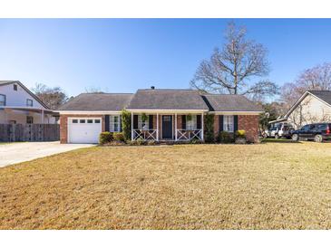 Charming brick home with a covered front porch, white picket fence, and well-manicured landscaping at 1649 Lauda Dr, Mount Pleasant, SC 29464