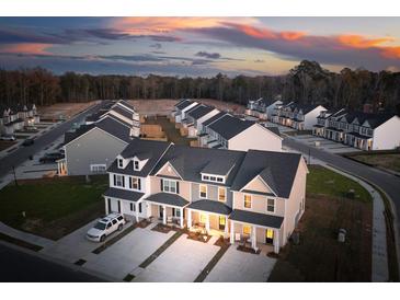 Aerial view of new construction townhomes featuring covered front porches and garages in a modern community at 207 Abercom Place Dr, Moncks Corner, SC 29461