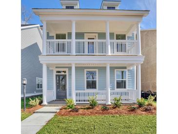 Charming two-story home with double covered porches, white columns, and manicured landscaping at 2205 Blue Bayou Blvd, Johns Island, SC 29455