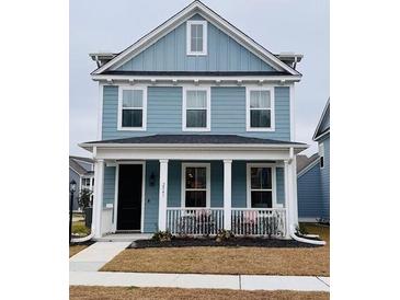 Charming two-story home with a covered front porch and manicured lawn at 2221 Blue Bayou Blvd, Johns Island, SC 29455