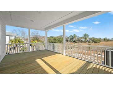 Spacious covered porch with wood flooring and scenic views of the surrounding landscape at 4432 Oakwood Ave, North Charleston, SC 29405