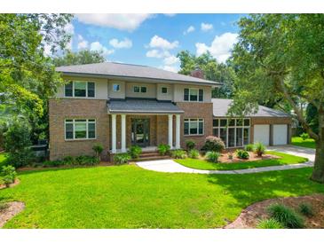Beautiful brick home with a manicured lawn, mature trees, and a two car garage at 652 E Hobcaw Dr, Mount Pleasant, SC 29464