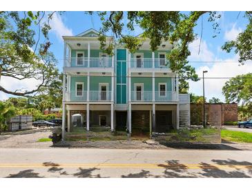 Charming two-story home with dual balconies, set against a backdrop of lush greenery and blue skies at 112 E Huron Ave # C, Folly Beach, SC 29439