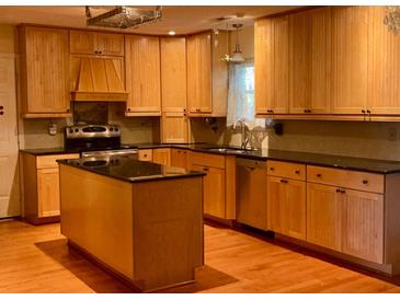 Spacious kitchen featuring wooden cabinets, black countertops, and a convenient center island at 115 St Awdry St, Summerville, SC 29485