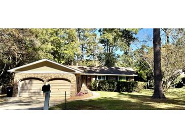 Charming brick home with a well-manicured lawn and mature trees at 125 Azalea Dr, Summerville, SC 29485