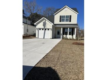 Charming two-story home featuring a welcoming front lawn and private garage at 3004 Harvey Ave, North Charleston, SC 29405