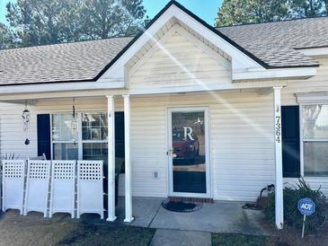 Welcoming front entrance of home featuring a covered porch, white columns, and ADT security sign at 7364 Suncatcher Dr, Hanahan, SC 29410