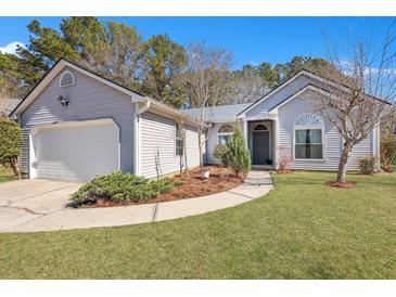 Charming single-story home featuring manicured lawn, tidy landscaping, and attached two-car garage at 106 Ranworth Ln, Summerville, SC 29485