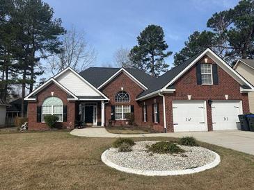 Charming one-story brick home featuring a two-car garage and manicured front yard at 109 Presidio Bnd, Summerville, SC 29483