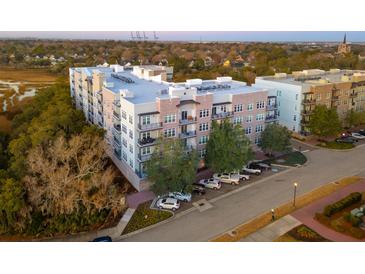 Beautiful new luxury apartment building with brick facade and balconies; well-manicured landscaping surrounds at 145 Pier View St # 403, Charleston, SC 29492