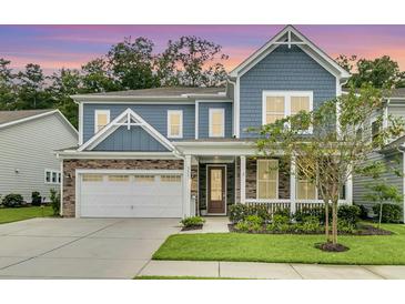 Charming two-story home featuring a stone facade, blue siding, and a well-manicured lawn at 331 Weston Hall Dr, Summerville, SC 29483