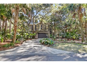 Charming home with a two-car garage surrounded by lush landscaping and mature trees at 87 Dungannon Hall, Kiawah Island, SC 29455