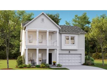 Charming two-story home with covered front porch and balcony, complemented by lush landscaping and a two-car garage at 1016 Swamp Rose Run, Summerville, SC 29485