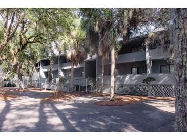 Condo building showcasing multiple units, each with a private balcony and mature trees adding shade and character at 291 Sea Cloud Cir # 291, Edisto Island, SC 29438