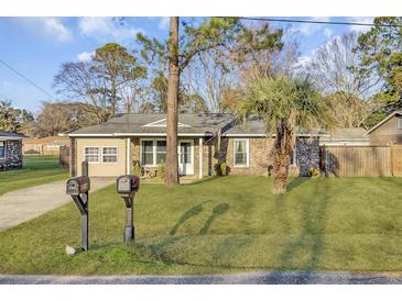 Charming brick home featuring a well-maintained lawn and mature trees at 4516 Logwood Dr, Ladson, SC 29456