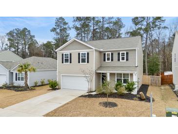 Charming two-story home with a well-manicured lawn and a welcoming entrance at 103 Cardinal Flower Ct, Moncks Corner, SC 29461