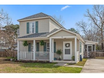 Charming two-story home featuring a welcoming front porch and lush green lawn at 12 Palmetto Park Dr, Charleston, SC 29407