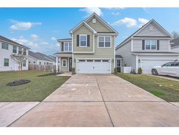Two-story home with green siding, a two-car garage, and a long concrete driveway at 132 Mcclellan Way, Summerville, SC 29483