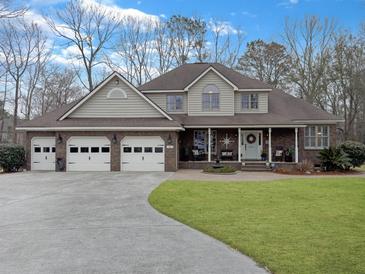 Charming home with a three-car garage, well-maintained lawn, and a welcoming front porch with rocking chairs at 135 Ashley Hill Dr, Goose Creek, SC 29445