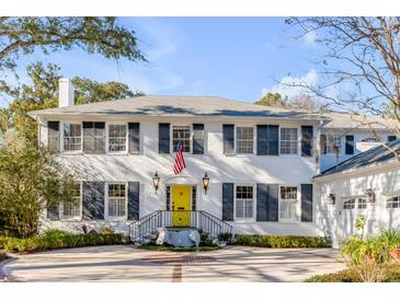 Charming two-story brick home with a bright yellow front door, manicured landscaping, and circular driveway at 14 Guerard Rd, Charleston, SC 29407