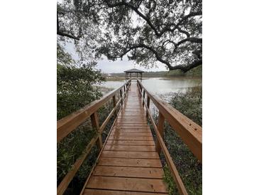 Picturesque wooden dock leading to a gazebo on the water with trees overhead at 2407 Edisto Ferry Rd, Edisto Island, SC 29438