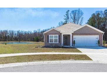 Charming single-story home featuring a well-manicured lawn and attached two-car garage at 409 Spruce Ivy St, Moncks Corner, SC 29461