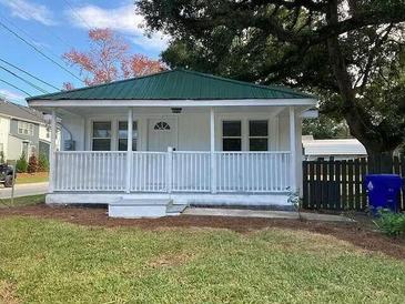 Charming single-story home with a green metal roof and a lovely white porch at 4230 S Rhett Ave, North Charleston, SC 29405