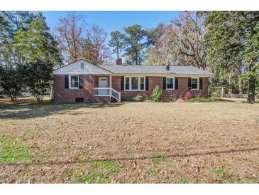Charming brick home featuring a well-maintained lawn and mature trees at 425 Ravenwood Rd, Walterboro, SC 29488