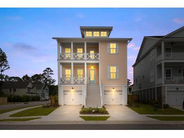 Two-story home showcasing a charming exterior with double balconies, complemented by a well-maintained front yard and garage at 325 Blowing Fresh Dr, Charleston, SC 29492
