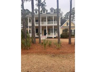Two-story yellow home with a double-decker front porch and dormer windows at 3711 Riverstation Ct, Mount Pleasant, SC 29466