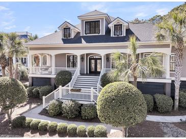 Charming two-story home with a welcoming front porch, manicured landscaping and mature palm trees at 4983 Sound View Dr, Mount Pleasant, SC 29466