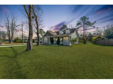 Charming home featuring a well-manicured lawn, inviting porch, and classic architectural details at 5037 Govan Rd, Hollywood, SC 29449
