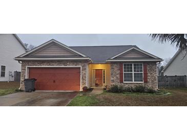 Charming single-story home with a stone facade and a red garage door provides curb appeal at 7646 Kinston St, North Charleston, SC 29418