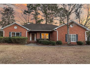 Charming brick home with manicured bushes and dark shutters set against a colorful sunset sky at 101 S Gateshead Crossing, Goose Creek, SC 29445