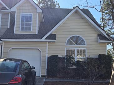 Charming two-story home with attached garage, manicured bushes, and appealing architectural details at 110 Greyson Cir, Goose Creek, SC 29445