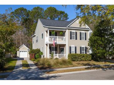 Charming two-story home featuring a double porch, landscaped yard, and detached garage, perfect for Gathering living at 1901 Hubbell Dr, Mount Pleasant, SC 29466