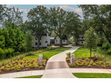 Stunning exterior of home with lush landscaping and a long, winding driveway at 215 Fell Pt, Daniel Island, SC 29492