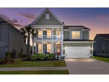 Charming two-story home with a welcoming porch, landscaped yard, and attached two-car garage at dusk at 219 Seaworthy St, Summerville, SC 29486