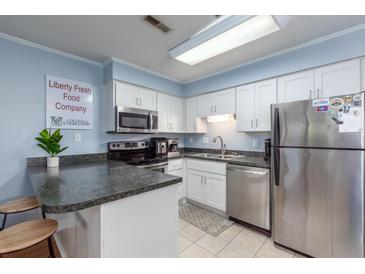 Bright kitchen featuring modern appliances, white cabinets, and a breakfast bar for convenient dining at 40 Bee Street # 314, Charleston, SC 29403