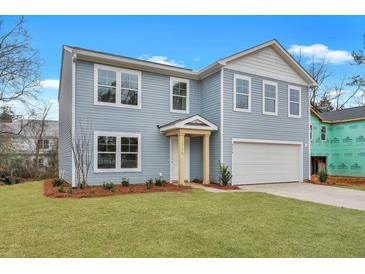Two-story home with blue siding, an attached garage and a manicured green lawn at 4179 Rising Tide Dr, Summerville, SC 29485