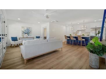 Open-concept living room features modern decor, hardwood floors, and a view of the kitchen island with barstool seating at 519 Bank St, Mount Pleasant, SC 29464