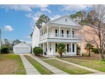 Charming two-story home featuring a double balcony and detached garage with a well-manicured front yard at 8957 N Red Maple Cir, Summerville, SC 29485
