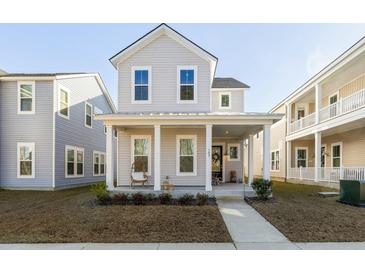 Charming two-story home featuring a welcoming front porch with classic columns and a well-manicured lawn at 109 Osprey Ridge Ln, Summerville, SC 29483