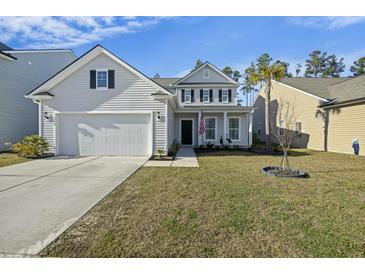 Charming two-story home features manicured lawn, attached garage, and inviting front porch at 310 Silent Bluff Dr, Summerville, SC 29486